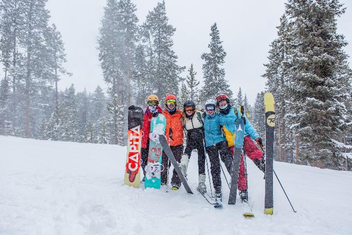 people in blue and red jacket and pants standing on snow covered ground during daytime